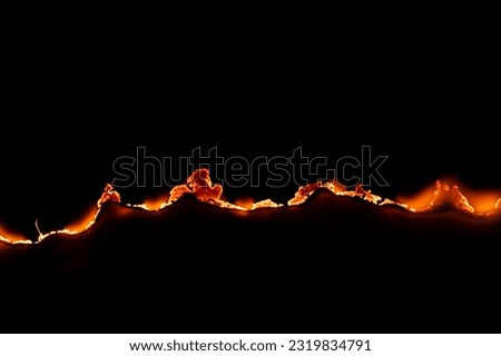 burning paper, glowing edge of paper on a black background Royalty-Free Stock Photo #2319834791