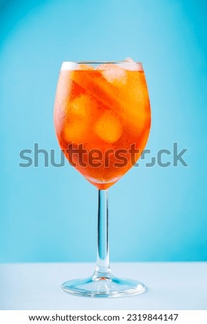 Aperol Spritz cocktail in glass on a blue background. Classic italian aperitif Aperol Spritz cocktail with orange and ice cubes. Close up Royalty-Free Stock Photo #2319844147
