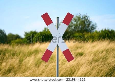 Traffic sign for a railroad crossing also called Andreas cross. Nature visible in the background.                            