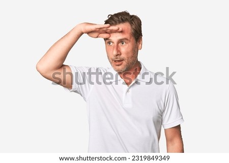 A middle-aged man isolated looking far away keeping hand on forehead. Royalty-Free Stock Photo #2319849349