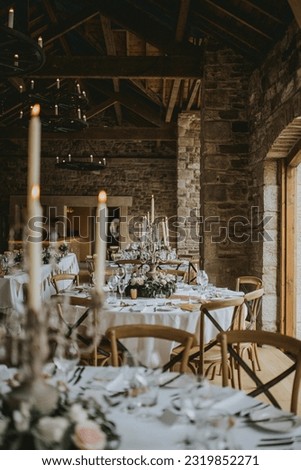 Authentic barn wedding table setup with candles and wooden chairs