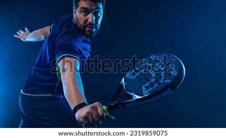 Padel Tennis Player with Racket in Hand. Paddle tenis, on a blue background. Download in high resolution. Royalty-Free Stock Photo #2319859075
