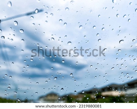 Water drops on the glass of my car and background with hometown and road.picture for background or wallpaper.