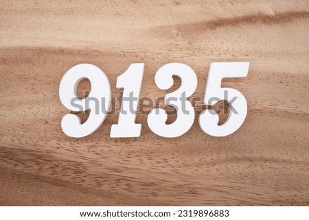 White number 9135 on a brown and light brown wooden background.