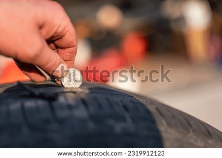 Quarter test on a tire to check wear by seeing the tread depth  Royalty-Free Stock Photo #2319912123