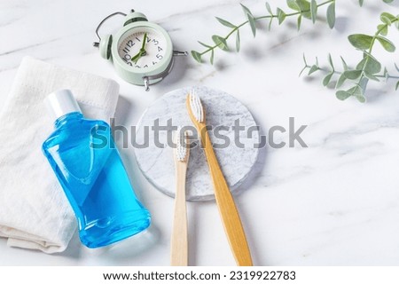 Oral care product, bamboo toothbrush and mouthwash with clock on marble background with copy space Royalty-Free Stock Photo #2319922783