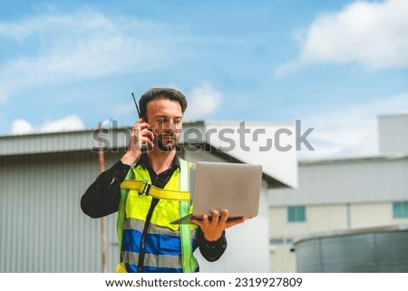 Elegant engineer holding a walkie talkies to working in determined and has a vision like a leader, Discussion and coordination between departments about problem solving, blue collar concept Royalty-Free Stock Photo #2319927809