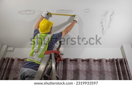 Worker fix leaking pipe in ceiling ,close-up of a stain on the ceiling. Royalty-Free Stock Photo #2319933597
