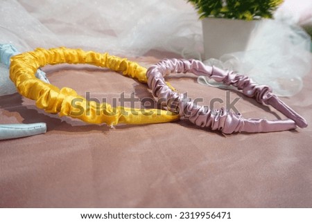 CLOSE UP COLORFUL SATIN HEADBAND FOR GIRL ON TILE FABRIC