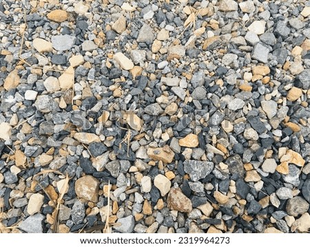 Stones of various sizes, both small and large, light and dark, interspersed naturally on rural roads in Thailand. Use this image as a background or part of a movie.