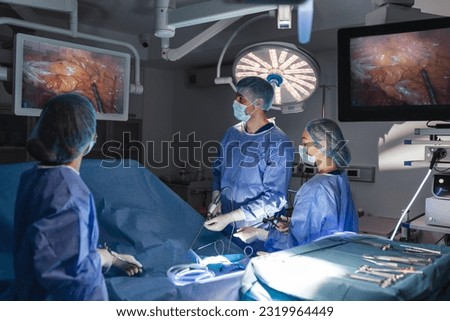 The surgeon's holing the instrument in abdomen of patient. The surgeon's doing laparoscopic surgery in the operating room. Minimally invasive surgery. Royalty-Free Stock Photo #2319964449