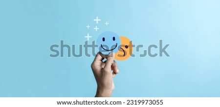 Hands holding sad face hiding or behind happy smiley face, bipolar and depression, mental health concept, personality, mood change, therapy healing split concept. Royalty-Free Stock Photo #2319973055