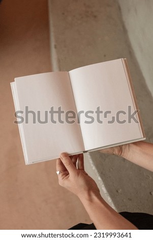 She is holding an empty notebook or book. Mockup book. Blank notebook, blank book Royalty-Free Stock Photo #2319993641