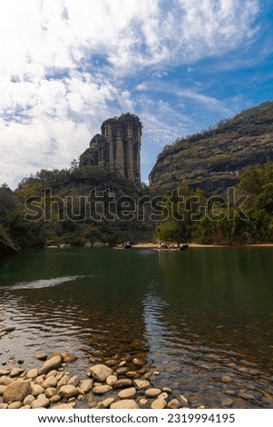 A rocky shore on the nine bend river or Jiuxi in Wuyishan or Mount wuyi scenic area in Wuyi China in fujian province. Deep blue sky, vertical picture with copy space for text