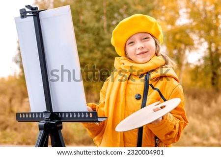 Autumn Baby Girl Drawing in Fall Leaves Park, Little Kid Painting, Children Creativity. little girl artist with a brush and paints in her hands in autumn in the park draws a landscape with leaves