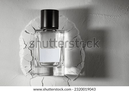 Perfume bottle with blank label on white textured background with free space for text