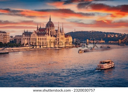 Old pleasure boats on Dunabe river with Parliament house on background. Stunning summer cityscape of Budapest. Amazing sunset in Hungary, Europe. Traveling concept background. Royalty-Free Stock Photo #2320030757
