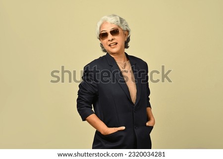  Portrait of 50s stylish businesswoman in sunglasses standing isolated beige background