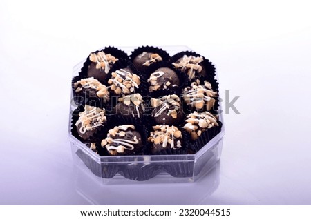 A box of chocolate truffles with nuts in it