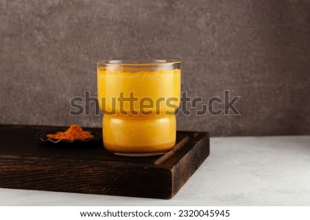 Golden Milk or Turmeric latte. Healthy drink with milk and honey to support the immune system. Traditional Indian drink. Royalty-Free Stock Photo #2320045945