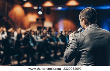 Speaker giving a talk on corporate business conference. Unrecognizable people in audience at conference hall. Business and Entrepreneurship event. Royalty-Free Stock Photo #2320052093