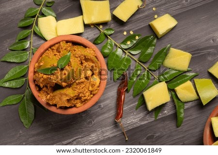 South india - Andhra spicy avakaya raw mango pickle in a traditional earthenware  on a dark rustic wooden background. selective focus. Royalty-Free Stock Photo #2320061849