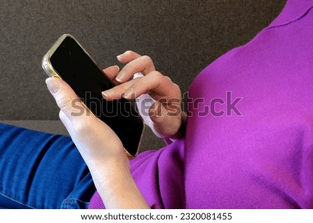 Older Middle Aged Woman using and text messaging by mobile phone near Window with old town background, indoor, Relaxed mature old 50s woman, search ecommerce offers on cell phone technology, closeup