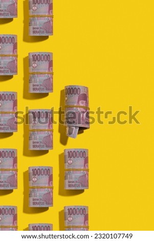 Indonesian rupiah money rolls flat lay on yellow background