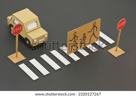 Black and white pedestrian crossing with cardboard stopped car and pedestrians cross the road safely - cartoon concept