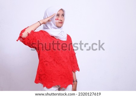 Young female student showing respect gesture isolated on white background celebrating indonesian independence day on 17 august  Royalty-Free Stock Photo #2320127619