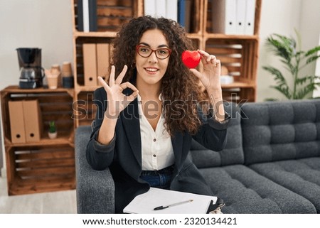 Young hispanic woman working on couple therapy at consultation office doing ok sign with fingers, smiling friendly gesturing excellent symbol 