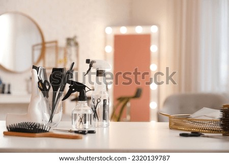 Different hairdressing tools on table in beauty salon Royalty-Free Stock Photo #2320139787