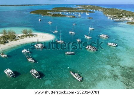 Drone aerial view of anchored sailing yacht in emerald Caribbean Sea, Stocking Island, Great Exuma, Bahamas.