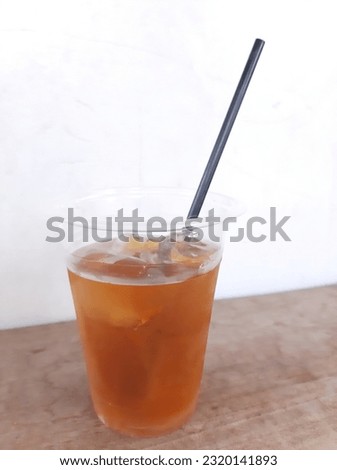 ice tea in plastic glass with black straw