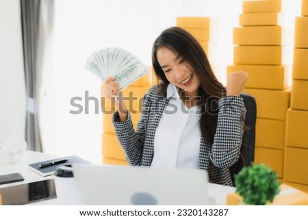 Portrait beautiful young asian woman work from home with laptop cash and cardboard box ready for shipping of online customer shopping