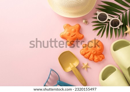 Adventure on a summer trip with children concept. Above view picture of marine shells, sand toys, panama hat, slippers, sunglasses and palm leaf on pink background, empty space offers copyspace