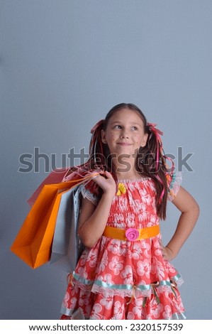 happy child in colorful dress with shopping bags