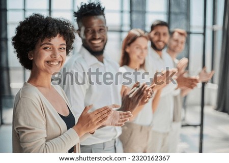Group of businesspeople sitting in a line and applauding. Royalty-Free Stock Photo #2320162367