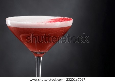 Refreshing low-alcohol cocktail with whipped juice and foam. Alcoholic refreshing cocktail in a glass with foam on a black background, frothy drink. Copy space