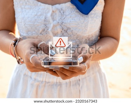 SMS spam and fake text message phishing concept. System hacked warning alert, email hack, scam malware spreading virus on message alert virtual on mobile smart phone screen in woman's hands. Royalty-Free Stock Photo #2320167343
