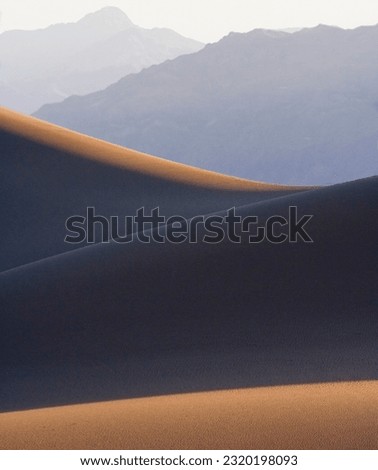Dune Curves and Funeral Mountains. Stovepipe Wells Dunes Royalty-Free Stock Photo #2320198093