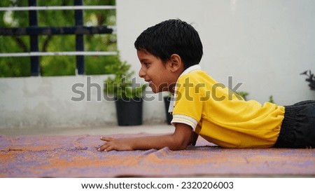 cute school boy doing yoga exercises or practicing at home. International yoga day celebration at home