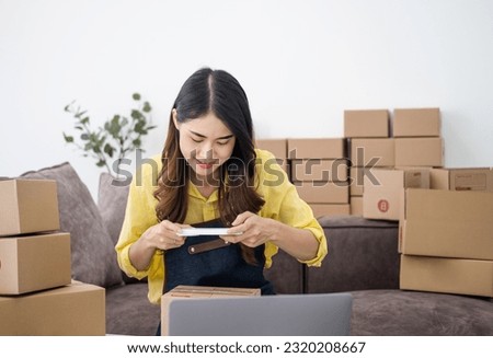 Young woman taking pictures during packaging With a mobile phone or smartphone digital camera to post online sales on the Internet and prepare the product box pack. selling ideas online
