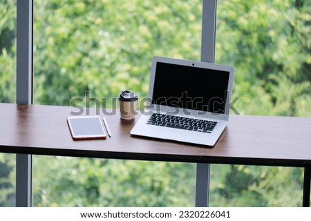 Laptops, tablets and coffee mugs on the desk.
