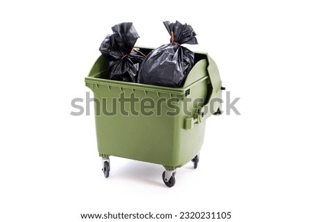 A green dust bin full of rubbish sacks Royalty-Free Stock Photo #2320231105
