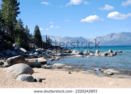 Early Fall picture of beautiful Lake Tahoe in mid-afternoon showcases the colorful glacier surrounded by lava rocks and the awe inspiring Sierra Mountains 