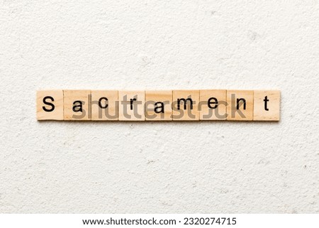 sacrament word written on wood block. sacrament text on table, concept.
