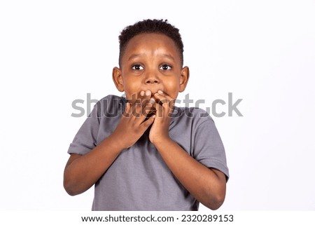 small boy with hand over mouth horrified Royalty-Free Stock Photo #2320289153