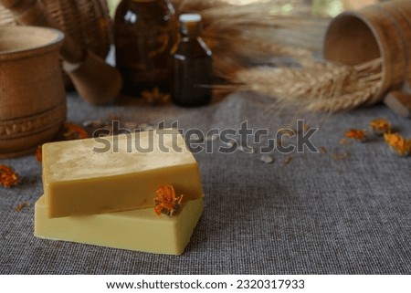 
Natural handmade soap with dry calendula (pot marigold) on rustic wooden background. Natural soap bars with essential oils and medicinal plants extracts. Side view,copy space for text, product place.