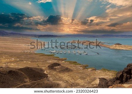 a gorgeous spring landscape at Lake Mead with vast blue water and majestic mountain ranges and boats and yachts docked in the marina with powerful clouds at sunset in Las Vegas Nevada USA Royalty-Free Stock Photo #2320326423
